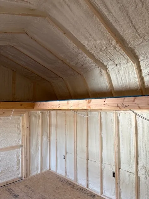 Closed-cell spray foam covering walls and vaulted ceiling of the same loft room after installation