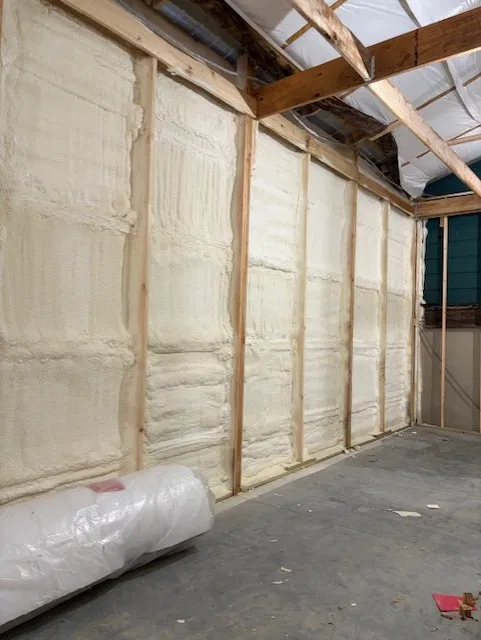 Finished residential wall with every stud bay filled with closed-cell spray foam