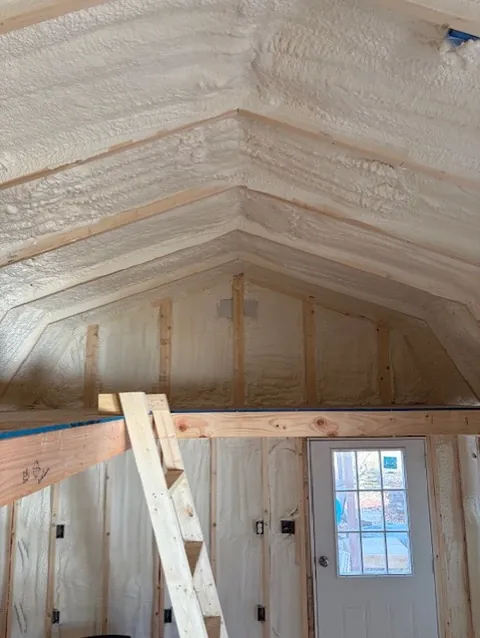 Close-up of spray foam insulation covering the peak of a vaulted ceiling